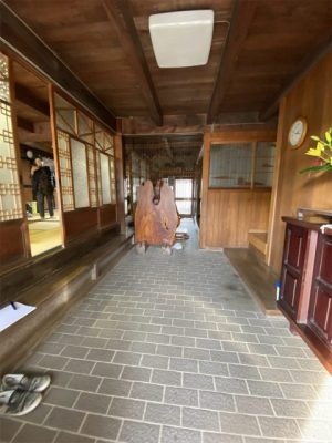 リフォーム前の通り土間の玄関。中庭まで抜けています。ガラスの入った建具のみで外部と区切られており、外気温と同じ状態です。ダイニングキッチンが向かって右側。不便なので床でつなげたいとのご希望でした。